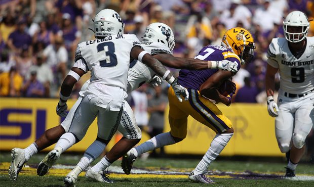 Wide receiver Justin Jefferson #2 of the LSU Tigers is tackled by safety Troy Lefeged Jr. #3 of the...
