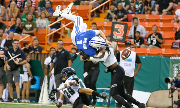 HONOLULU, HI - DECEMBER 24: Zach Wilson #1 of the BYU Cougars is upended by Donovan Dalton #29 of t...