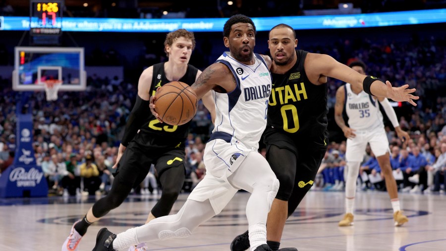 Dallas Mavericks guard Kyrie Irving defended by Utah Jazz forward Lauri Markkanen and Talen Horton-...