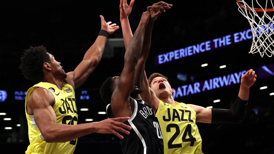 Spencer Dinwiddie #26 of the Brooklyn Nets and Walker Kessler #24 of the Utah Jazz compete for a re...